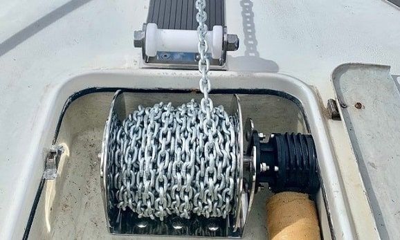 Ankerwinsch mit aufgewickelter Kette an Bord einer Yacht