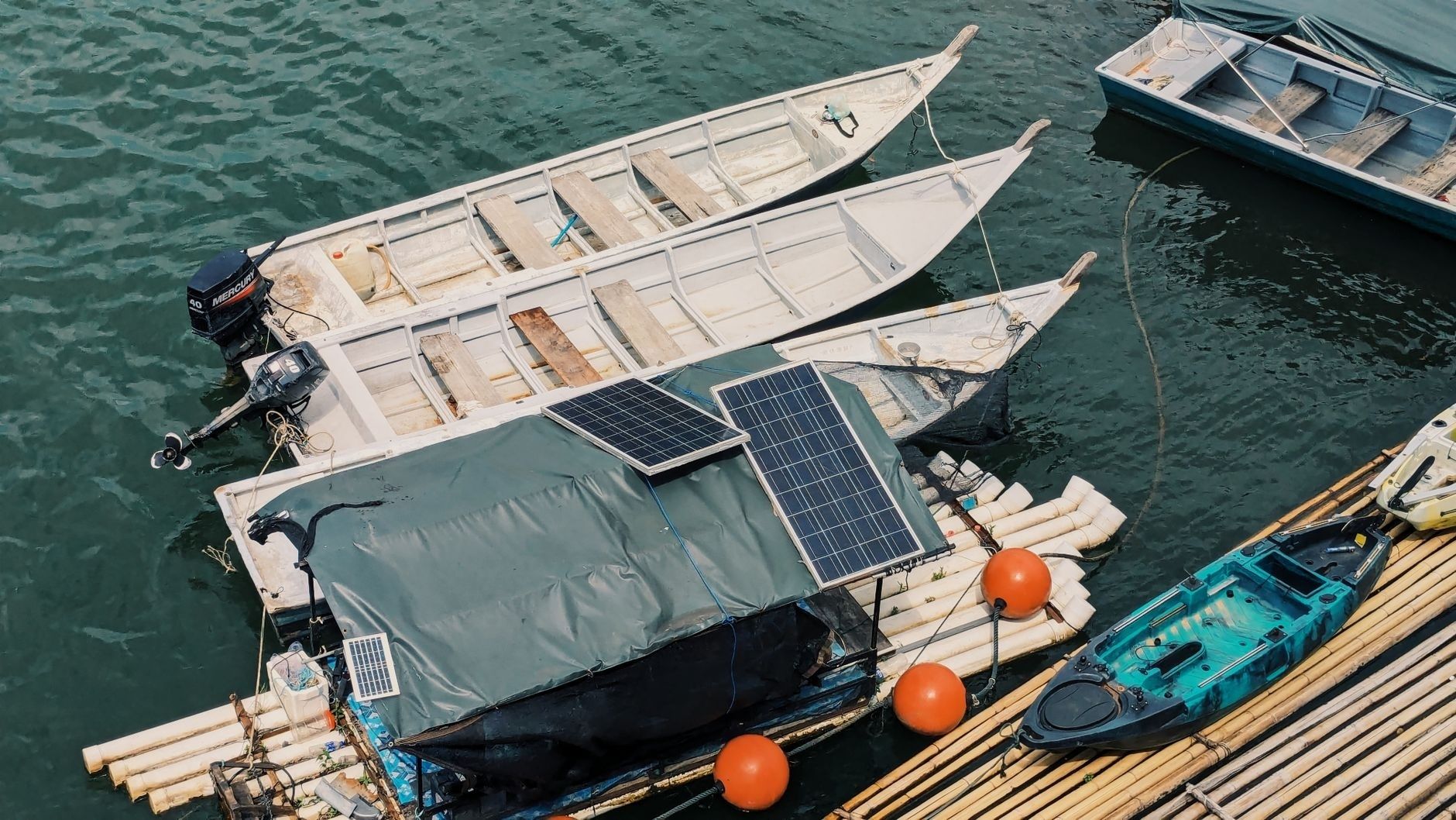 Boote mit Solarmodulen an einem schwimmenden Holzsteg